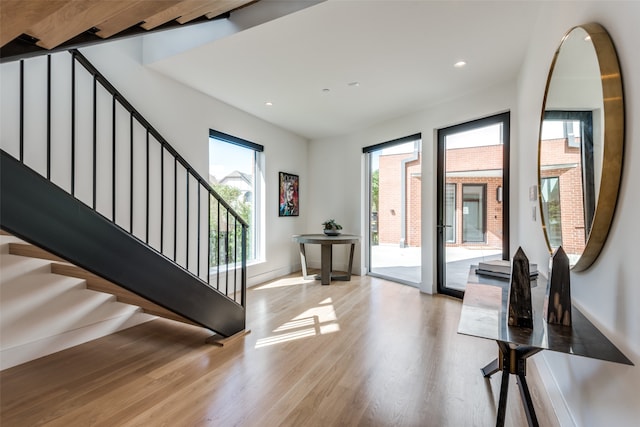 entrance foyer featuring beamed ceiling and light wood-type flooring