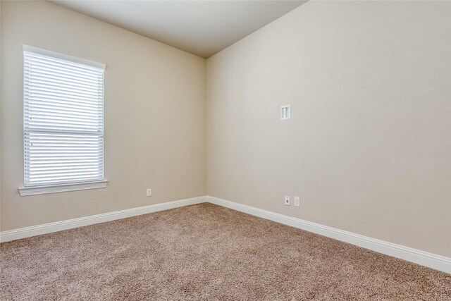 carpeted empty room featuring lofted ceiling