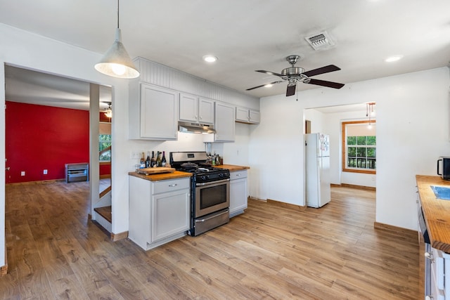 kitchen with stainless steel appliances, light wood-type flooring, ceiling fan, decorative light fixtures, and wood counters