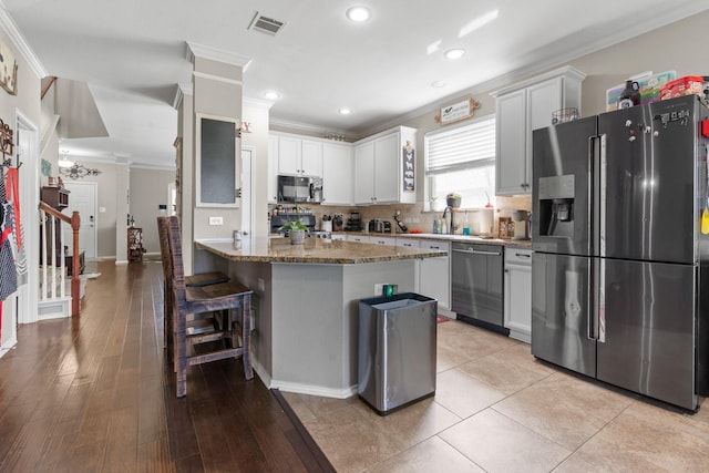 9433 Drovers View Trl, Fort Worth, TX 76131 - kitchen with a breakfast bar, appliances with stainless steel finishes, ornamental molding, stone countertops, and a peninsula