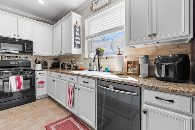 kitchen featuring black appliances, ornamental molding, light stone counters, and white cabinets