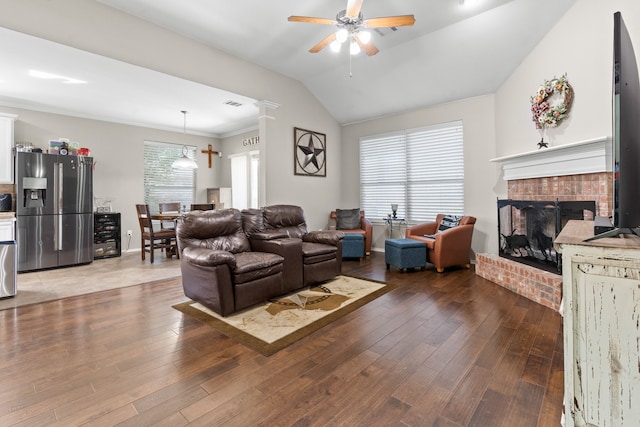 living room featuring crown molding, hardwood / wood-style floors, ceiling fan, and a brick fireplace