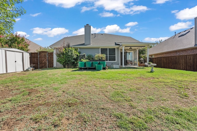 back of property with a lawn, a storage shed, ceiling fan, and a patio area