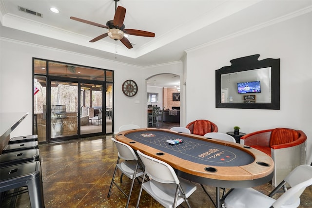 dining space featuring ceiling fan, a tray ceiling, and crown molding