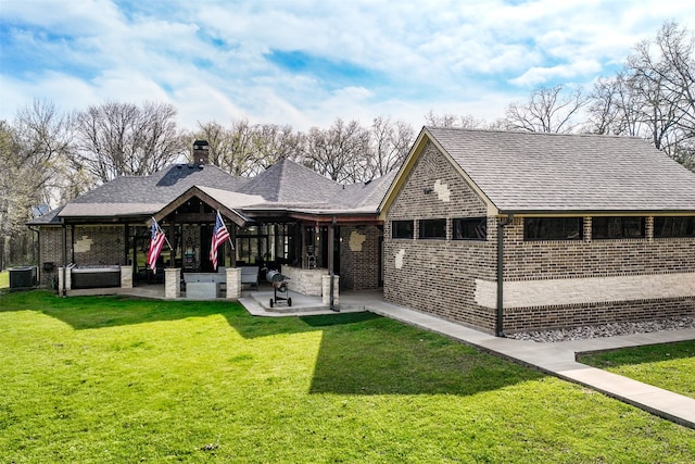 view of front facade featuring a front lawn, a patio area, and central air condition unit