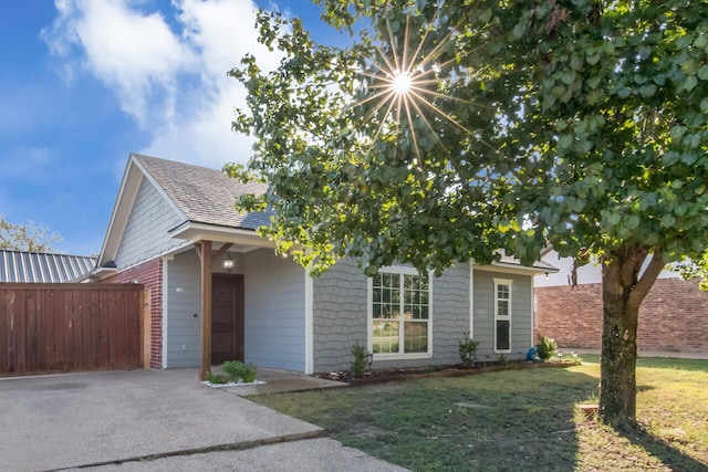 view of property hidden behind natural elements with a front yard