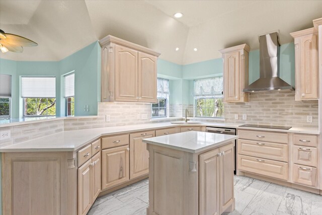 kitchen featuring a center island, lofted ceiling, kitchen peninsula, wall chimney exhaust hood, and ceiling fan