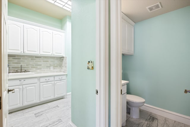 bathroom featuring decorative backsplash, vanity, and toilet