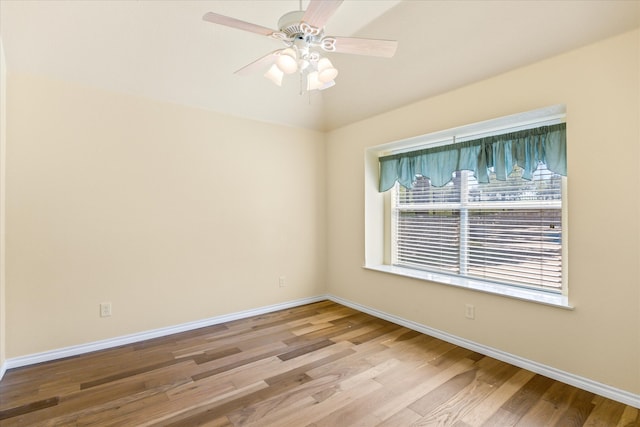 empty room with ceiling fan and light hardwood / wood-style flooring