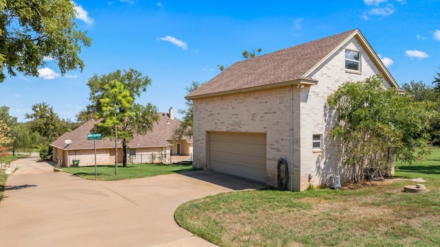 view of side of property featuring a garage and a yard