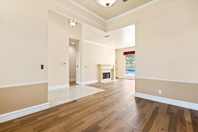 unfurnished living room with crown molding, hardwood / wood-style floors, and a high end fireplace