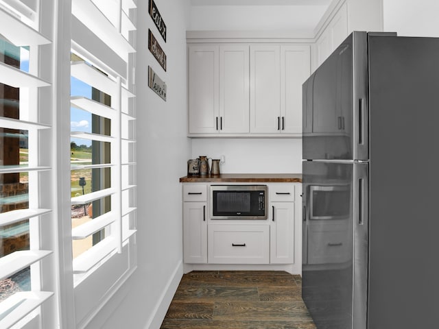 kitchen featuring appliances with stainless steel finishes, dark hardwood / wood-style floors, white cabinetry, and butcher block counters