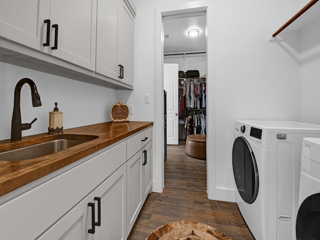 laundry area with cabinets, sink, dark wood-type flooring, and washing machine and dryer