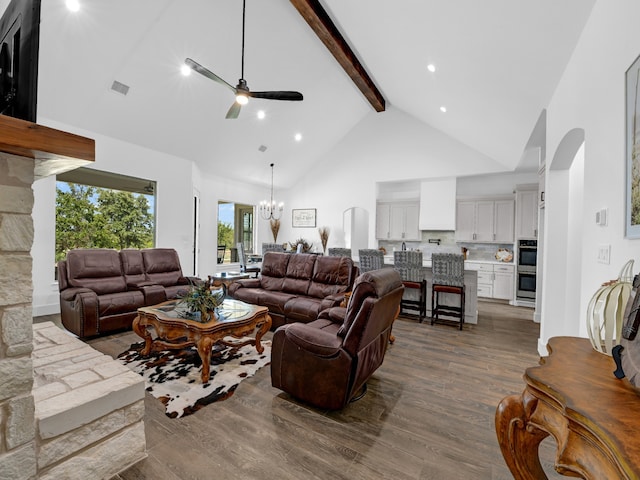 living room featuring ceiling fan with notable chandelier, beamed ceiling, high vaulted ceiling, and dark hardwood / wood-style flooring