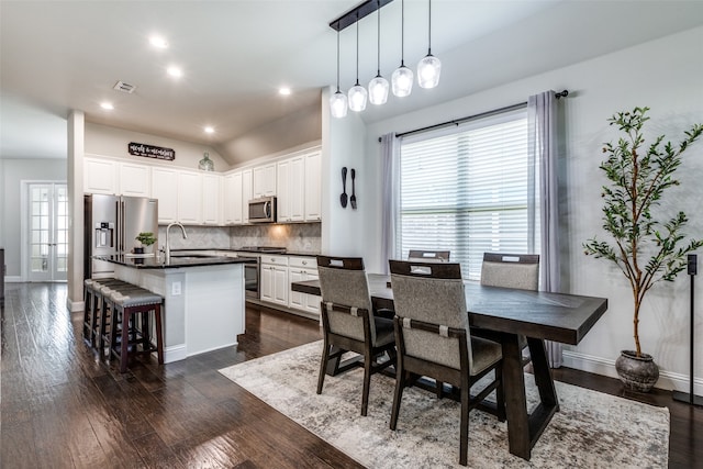 dining area featuring sink and dark wood-type flooring