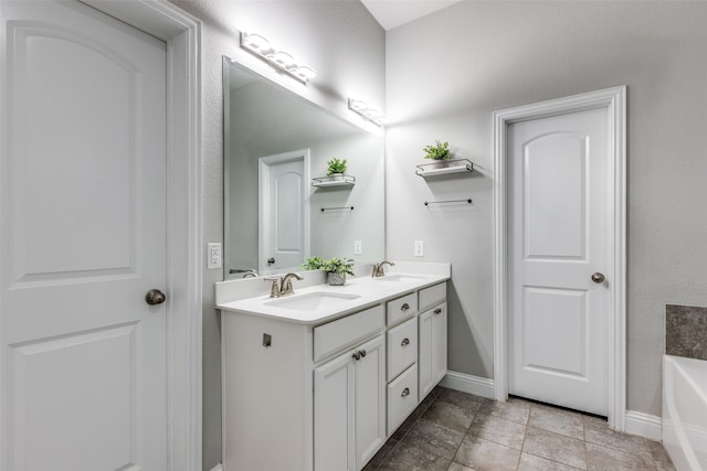 bathroom with vanity, a bath, and tile patterned floors