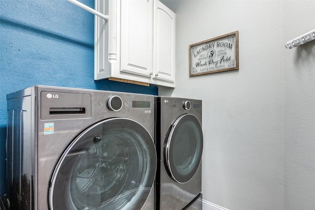 laundry room featuring cabinets and washer and clothes dryer