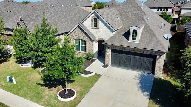 french country home with a front yard and a garage