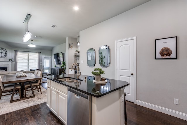 kitchen featuring hanging light fixtures, a kitchen island with sink, white cabinetry, dishwasher, and dark hardwood / wood-style floors