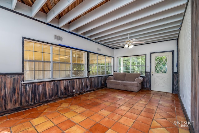 unfurnished sunroom featuring beam ceiling and ceiling fan