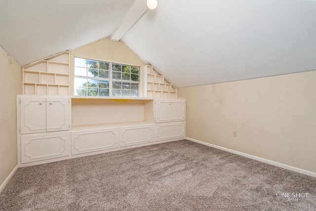 bonus room with carpet flooring, lofted ceiling with beams, and built in features