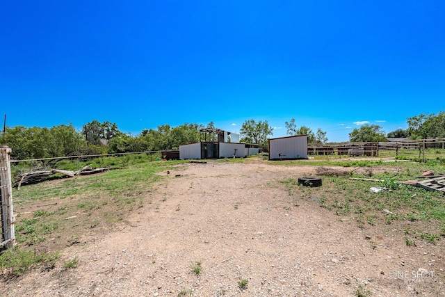 view of yard featuring a rural view and a storage shed