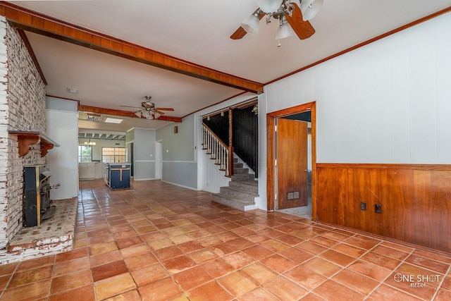 unfurnished living room featuring ornamental molding, a brick fireplace, and ceiling fan