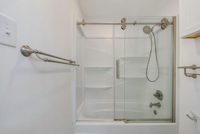 bathroom featuring bath / shower combo with glass door