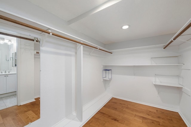 walk in closet with wood-type flooring and sink