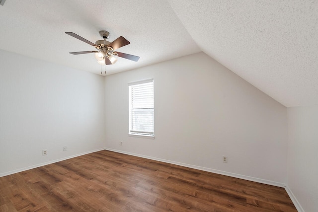 additional living space featuring ceiling fan, a textured ceiling, lofted ceiling, and dark hardwood / wood-style flooring