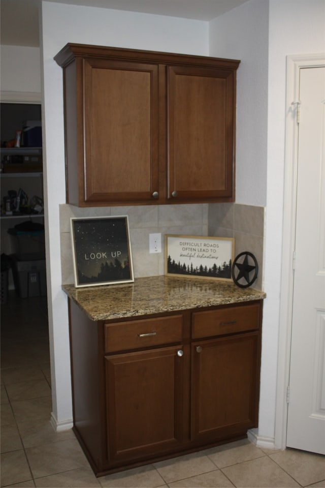 kitchen with backsplash, stone counters, and light tile patterned floors