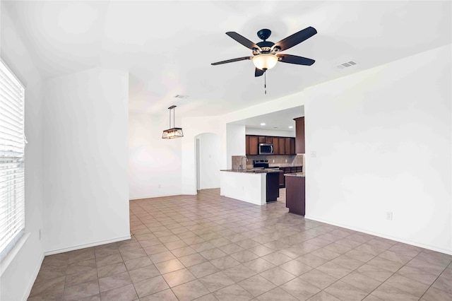 tiled spare room featuring ceiling fan