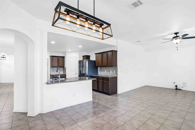 unfurnished living room with ceiling fan, light tile patterned flooring, plenty of natural light, and sink