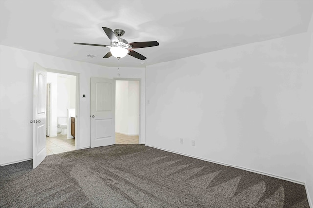 unfurnished bedroom with ceiling fan, light carpet, and ensuite bathroom