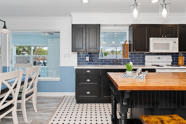 kitchen featuring hanging light fixtures, sink, ornamental molding, white appliances, and butcher block countertops