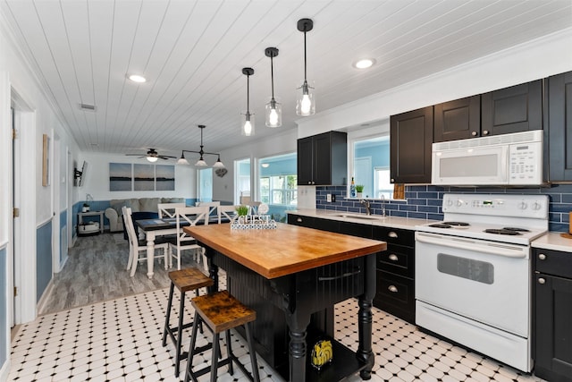 kitchen featuring white appliances, butcher block countertops, wooden ceiling, a breakfast bar, and decorative backsplash
