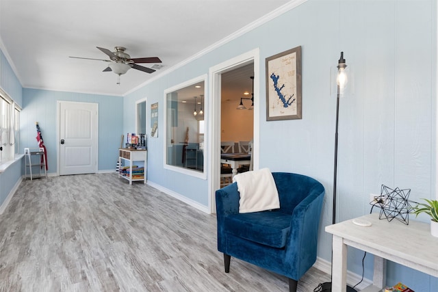 living area featuring ornamental molding, baseboards, visible vents, ceiling fan, and wood finished floors