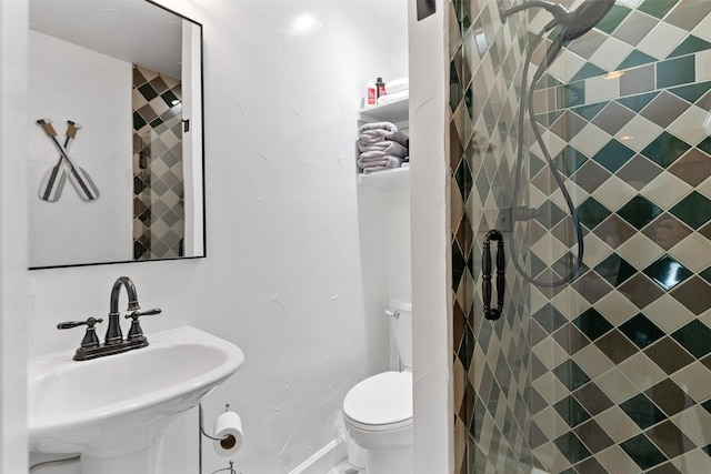 full bath featuring a sink, toilet, and a shower stall