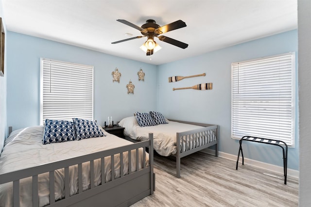 bedroom with baseboards, a ceiling fan, and light wood finished floors