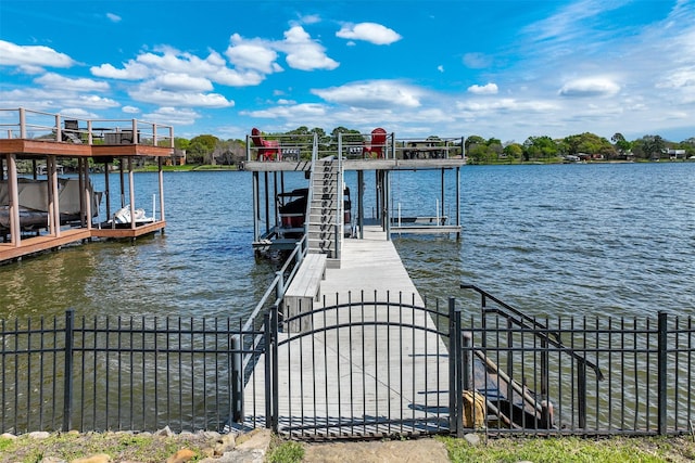 view of dock featuring a water view, fence, and boat lift