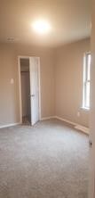 unfurnished bedroom with a closet and carpet flooring