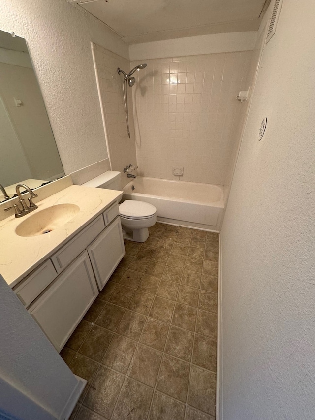 full bathroom featuring tiled shower / bath, vanity, and toilet