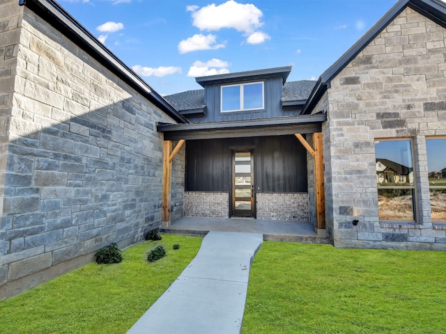 view of exterior entry with a yard