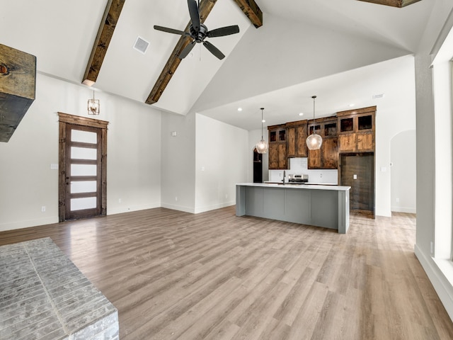 unfurnished living room featuring ceiling fan, light wood-type flooring, high vaulted ceiling, and beam ceiling