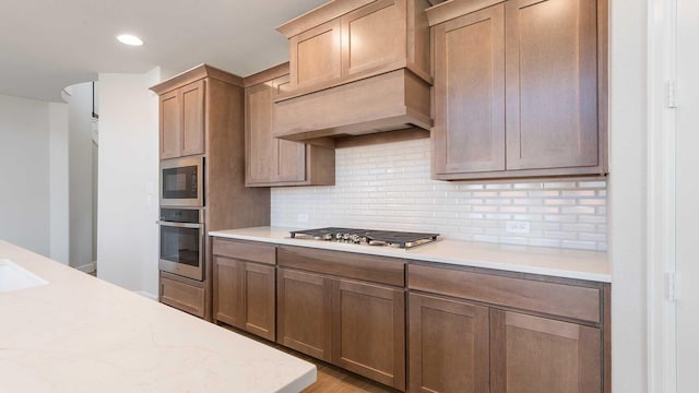 kitchen featuring stainless steel appliances, recessed lighting, backsplash, and custom range hood