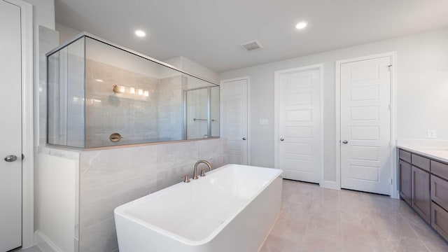 full bath featuring recessed lighting, a soaking tub, visible vents, a stall shower, and vanity