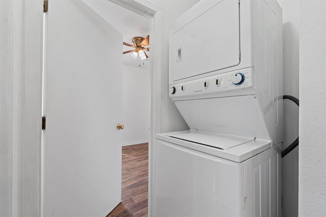 clothes washing area with hardwood / wood-style floors and stacked washer / dryer