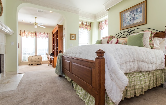 carpeted bedroom featuring ceiling fan, ornamental molding, and multiple windows