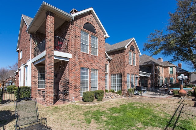 view of property exterior featuring a patio area, a lawn, and a balcony