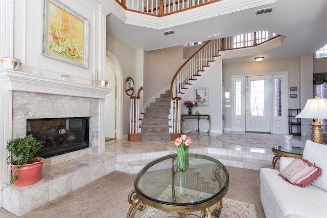 living room featuring a tiled fireplace and a towering ceiling